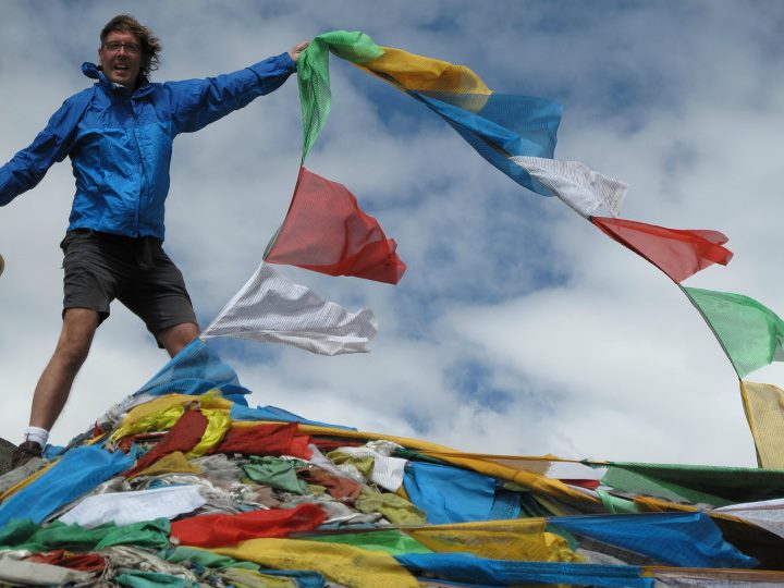 Placing prayer flags on a mountain in Tibet.