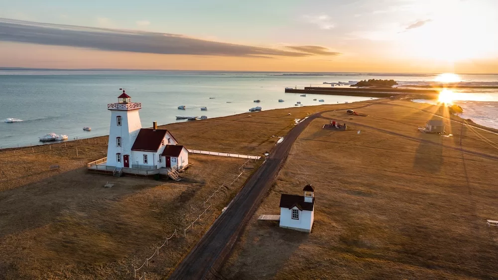 An aerial drone photograph of Wood Islands Lighthouse on Prince Edward Island at golden hour. 