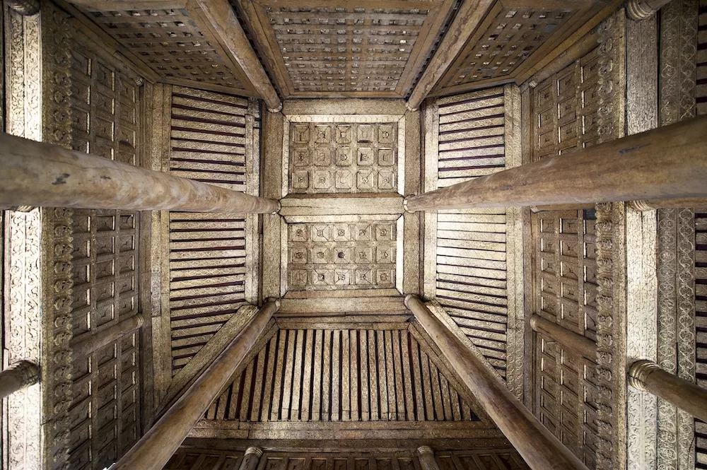 The ornate teak carvings of the Bagaya buddhist monastery, Ava, Mandalay, Myanmar. Photo courtesy of iStock/pilesasmiles.