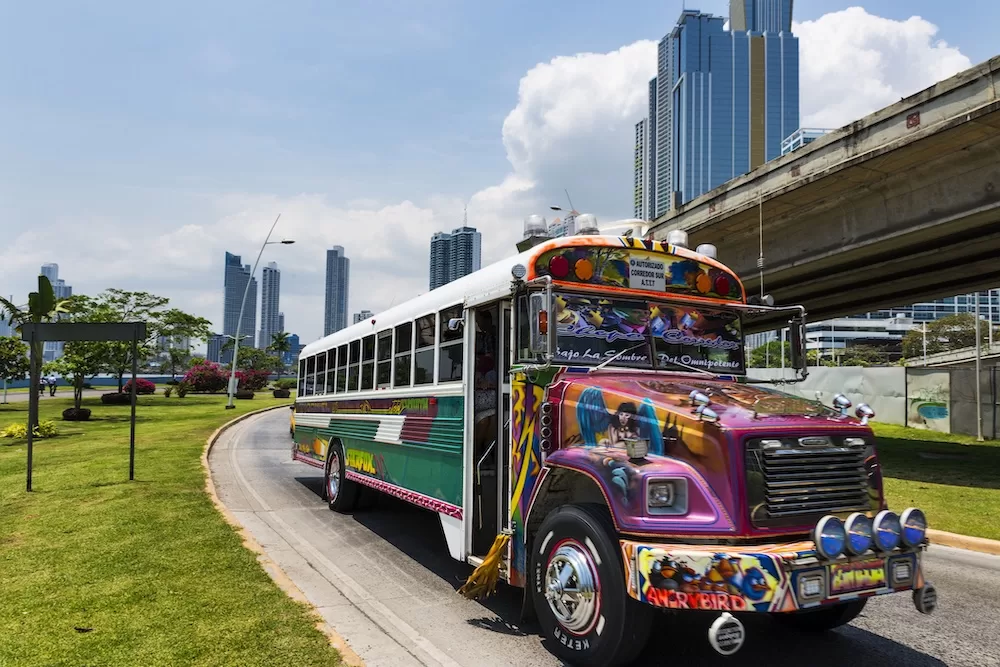 Red Devil buses are common public transportation options, often painted in bright colors and symbols. Photo courtesy of iStock/Tiago_Fernandez